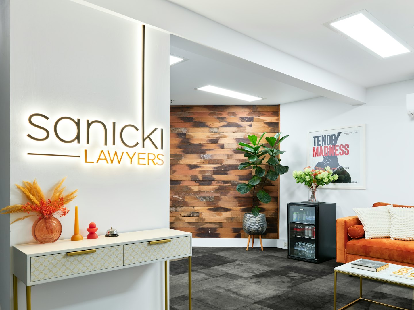 Modern office reception area featuring a sofa and Sanicki Lawyers sign.